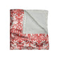 Floral patterned blanket with red and white design on a gray background