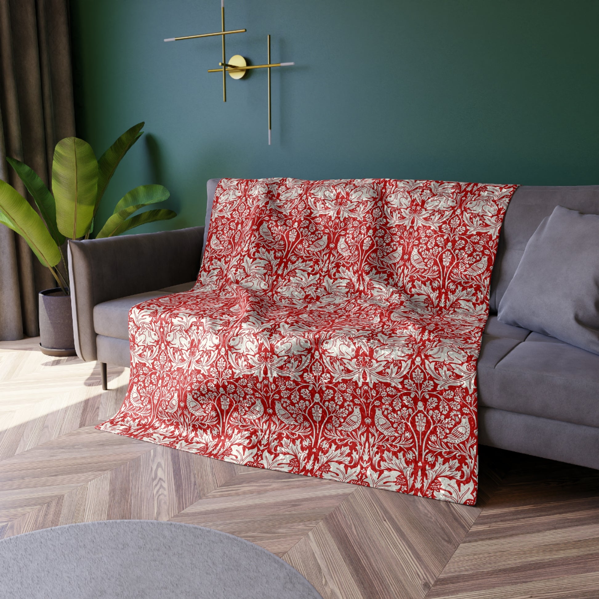 Red and white patterned blanket draped over a gray sofa in a living room.