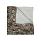 A crushed velvet blanket with a floral William Morris & Co pattern in muted colours and a silky finish.