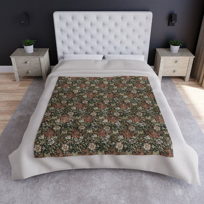 A crushed velvet blanket with a floral pattern in muted colors and a silky finish.