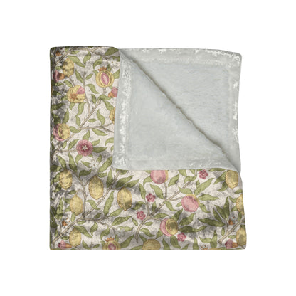 Floral-patterned quilt with a plain gray back on a white background