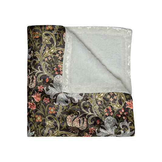 A lush crushed velvet blanket with a floral pattern inspired by William Morris, in shades of green and brown, with hemmed edges and a silky finish.