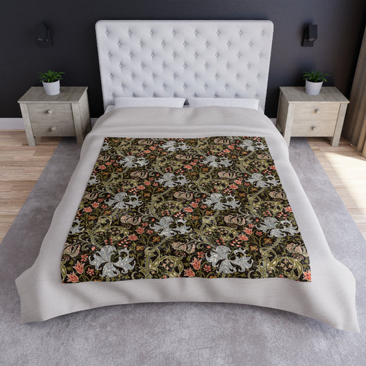 A lush crushed velvet blanket with a floral pattern inspired by William Morris, in shades of green and brown, with hemmed edges and a silky finish.