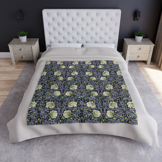 A plush, velvet blanket with a William Morris & Co floral pattern in shades of purple and a silky finish, hemmed edges, and a visible plush reverse side.