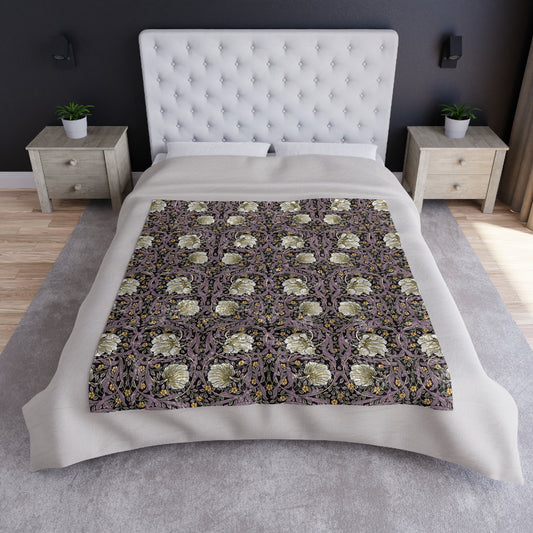 A plush velvet blanket with a William Morris & Co floral pattern in shades of purple and green, displaying a silky finish and hemmed edges.