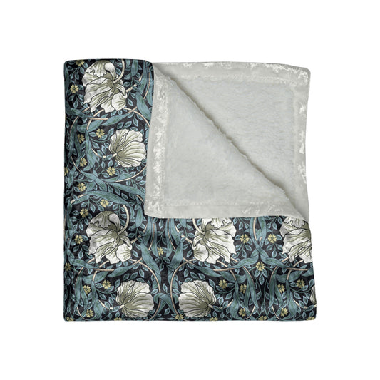 A plush velvet blanket with a William Morris & Co floral pattern in shades of gray and a silky finish, hemmed edges, inspired by William Morris' Pimpernel Collection.