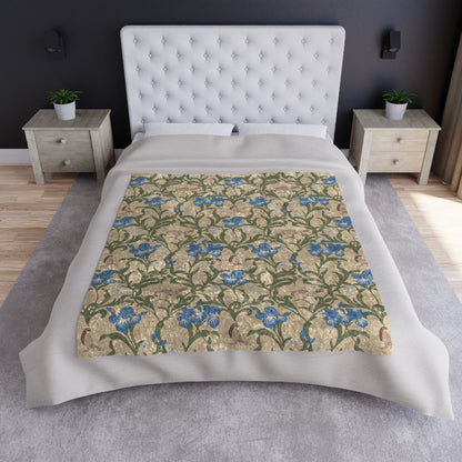 A plush velvet blanket with a floral pattern in blue and green colors on a beige background, displayed on a flat surface.
