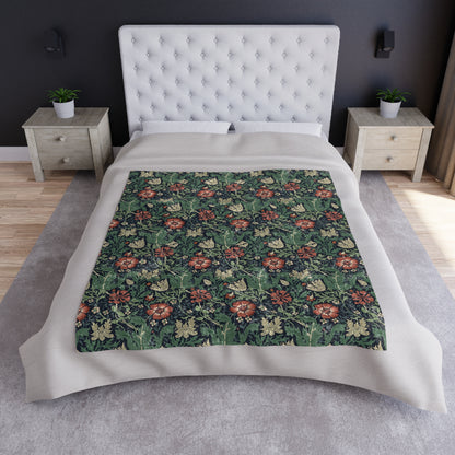 A lush crushed velvet blanket with a William Morris & Co floral pattern in green, red, and brown colours, displayed on a white background.