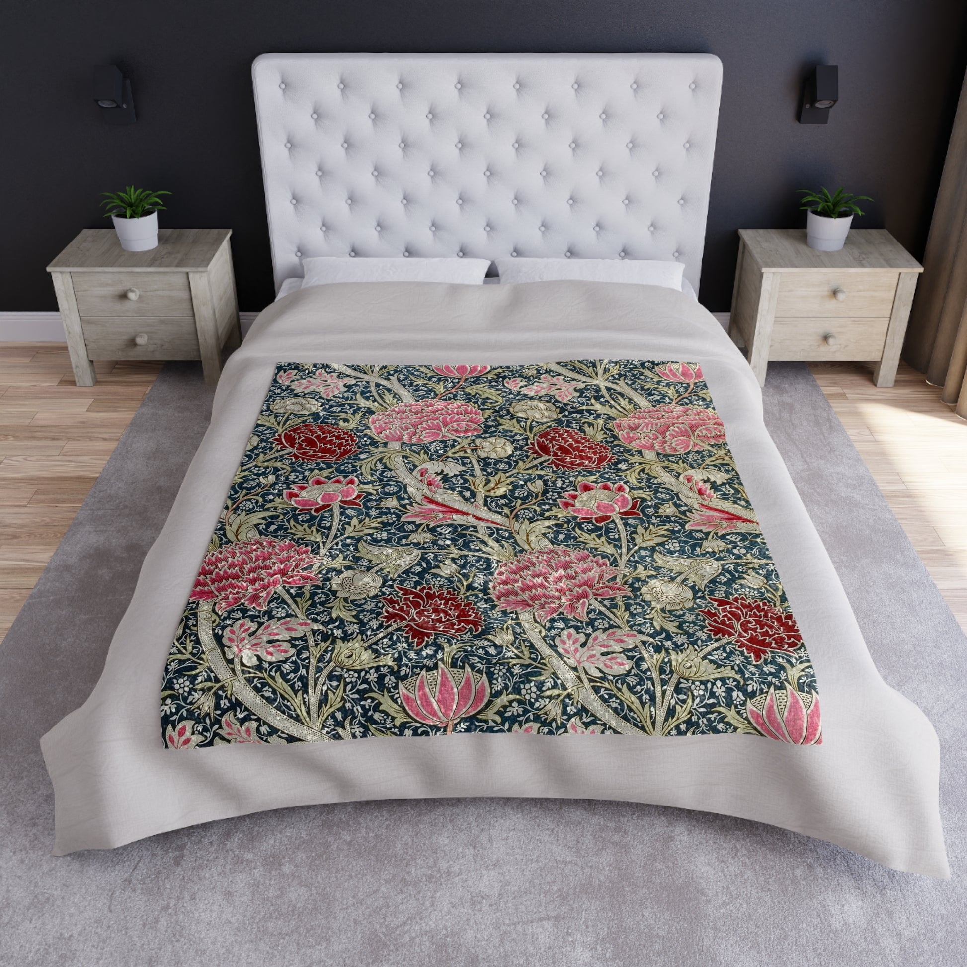 A lush crushed velvet blanket with a William Morris & Co floral pattern in shades of red, blue, and green, hemmed edges and a silky finish.