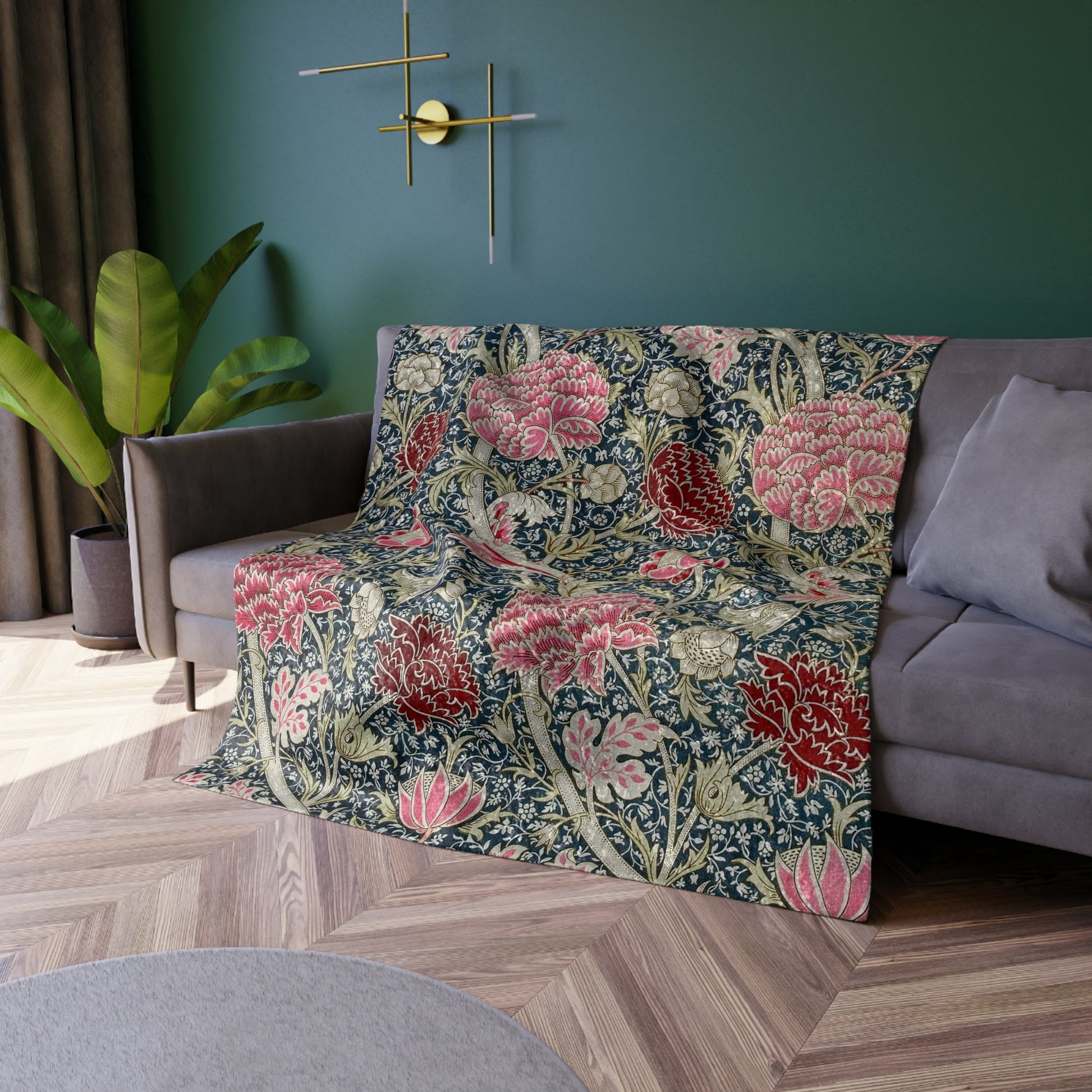 A lush crushed velvet blanket with a William Morris & Co floral pattern in shades of red, blue, and green, hemmed edges and a silky finish.