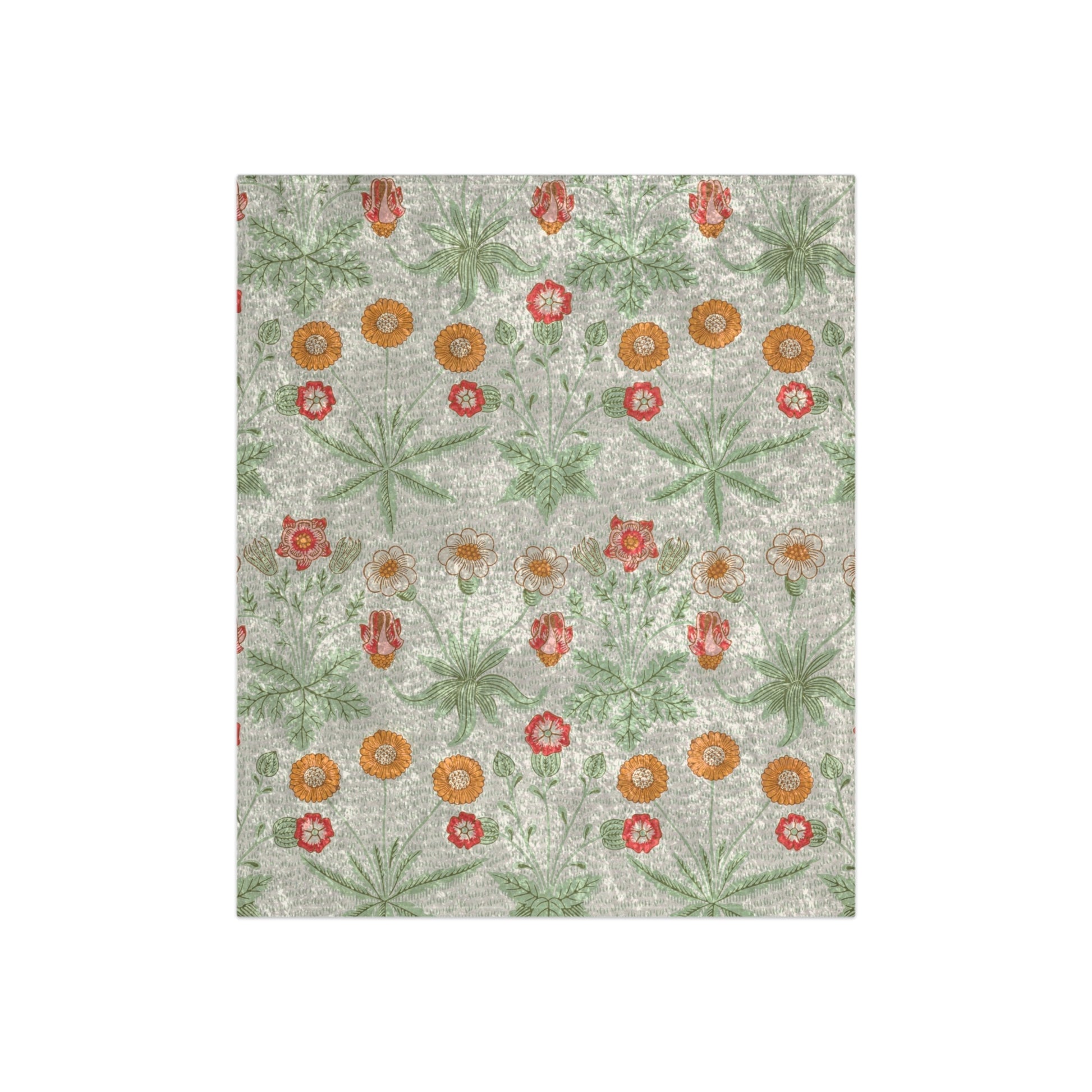 A lush crushed velvet blanket with a pattern inspired by William Morris, featuring daisy motifs in a green, red, and white color palette on a gray background.