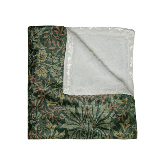 A lush crushed velvet blanket with a floral William Morris & Co pattern in green and brown colours, displayed on a white background.