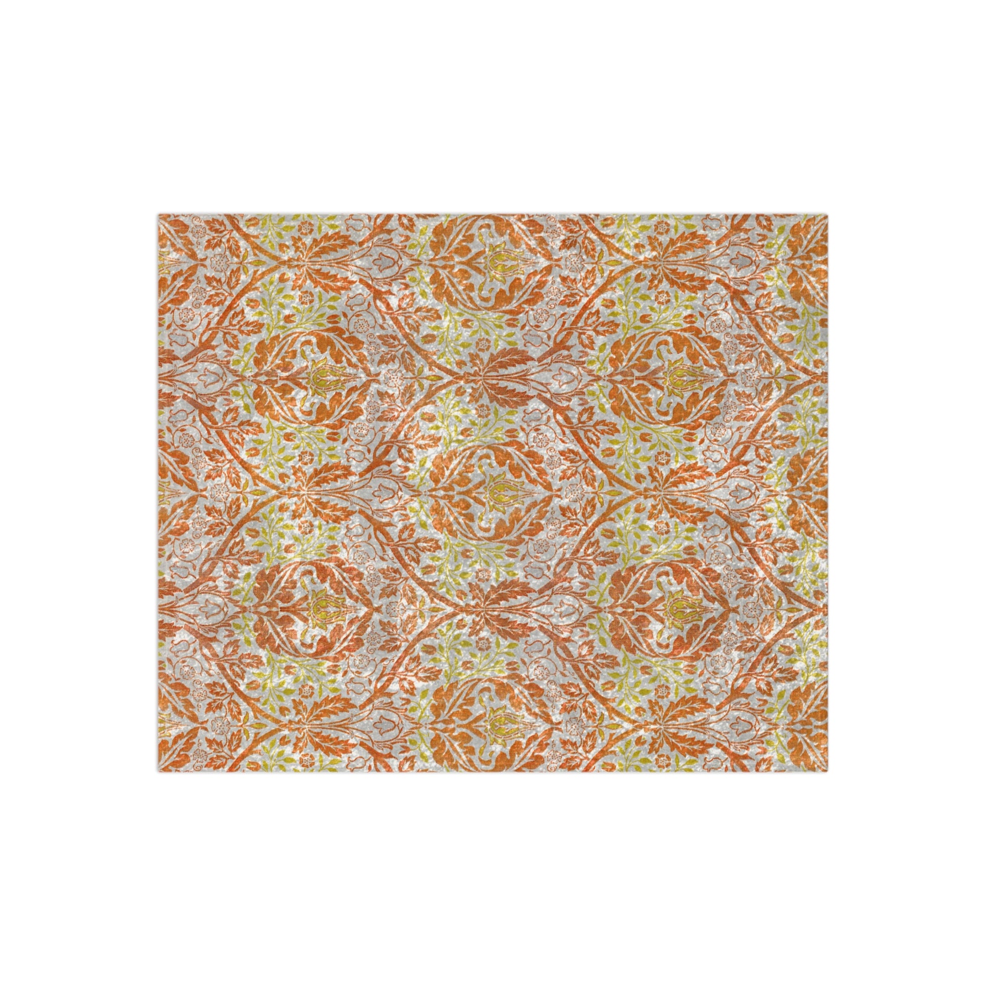 A crushed velvet blanket with a William Morris & Co floral pattern in shades of orange, yellow, and green on a white background, folded to show both the patterned side and the solid silky finish.