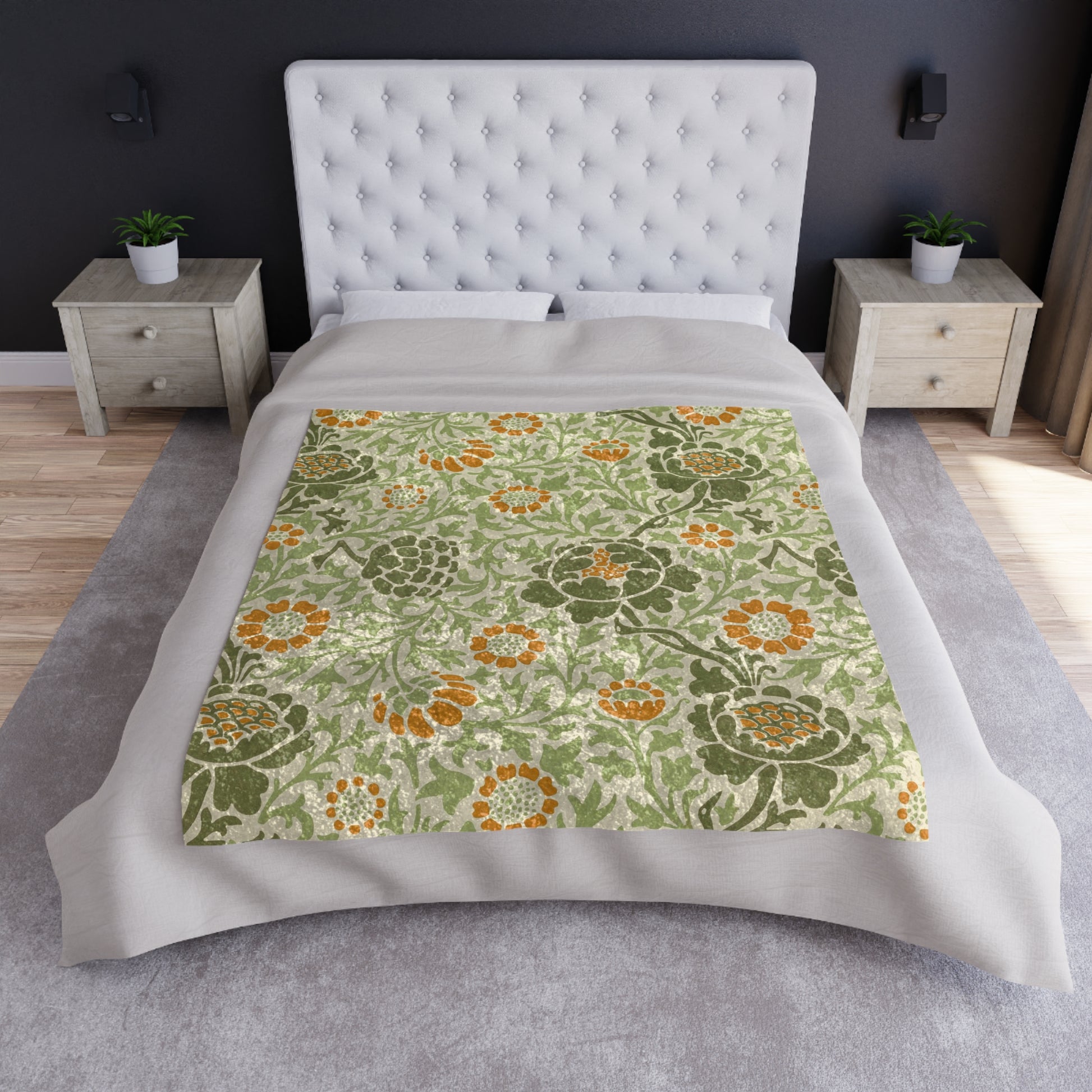 A plush, velvet blanket with aWilliam Morris  floral pattern in shades of green and orange, folded to show both the front and back with hemmed edges.