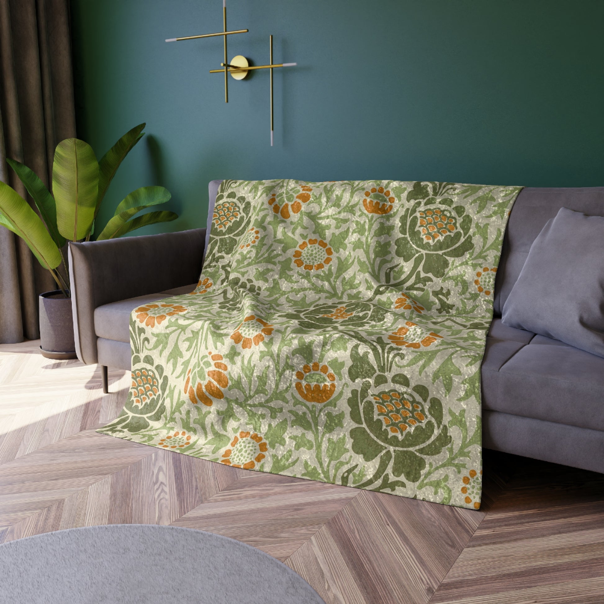 A plush, velvet blanket with aWilliam Morris  floral pattern in shades of green and orange, folded to show both the front and back with hemmed edges.