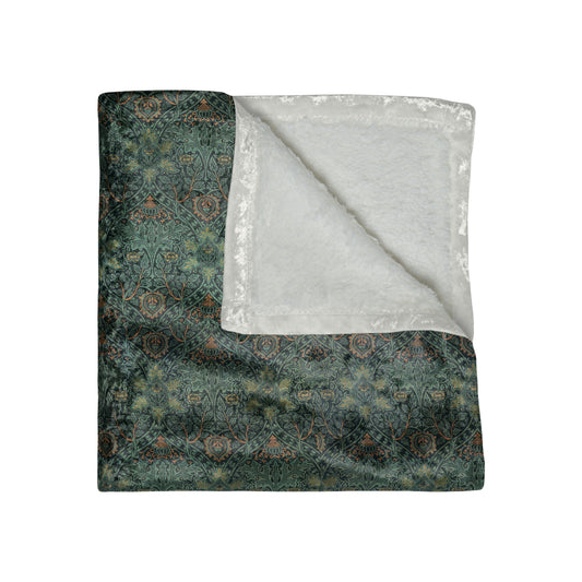 A lush crushed velvet blanket with a William Morris & Co floral pattern in green and brown shades, displayed on a white background.