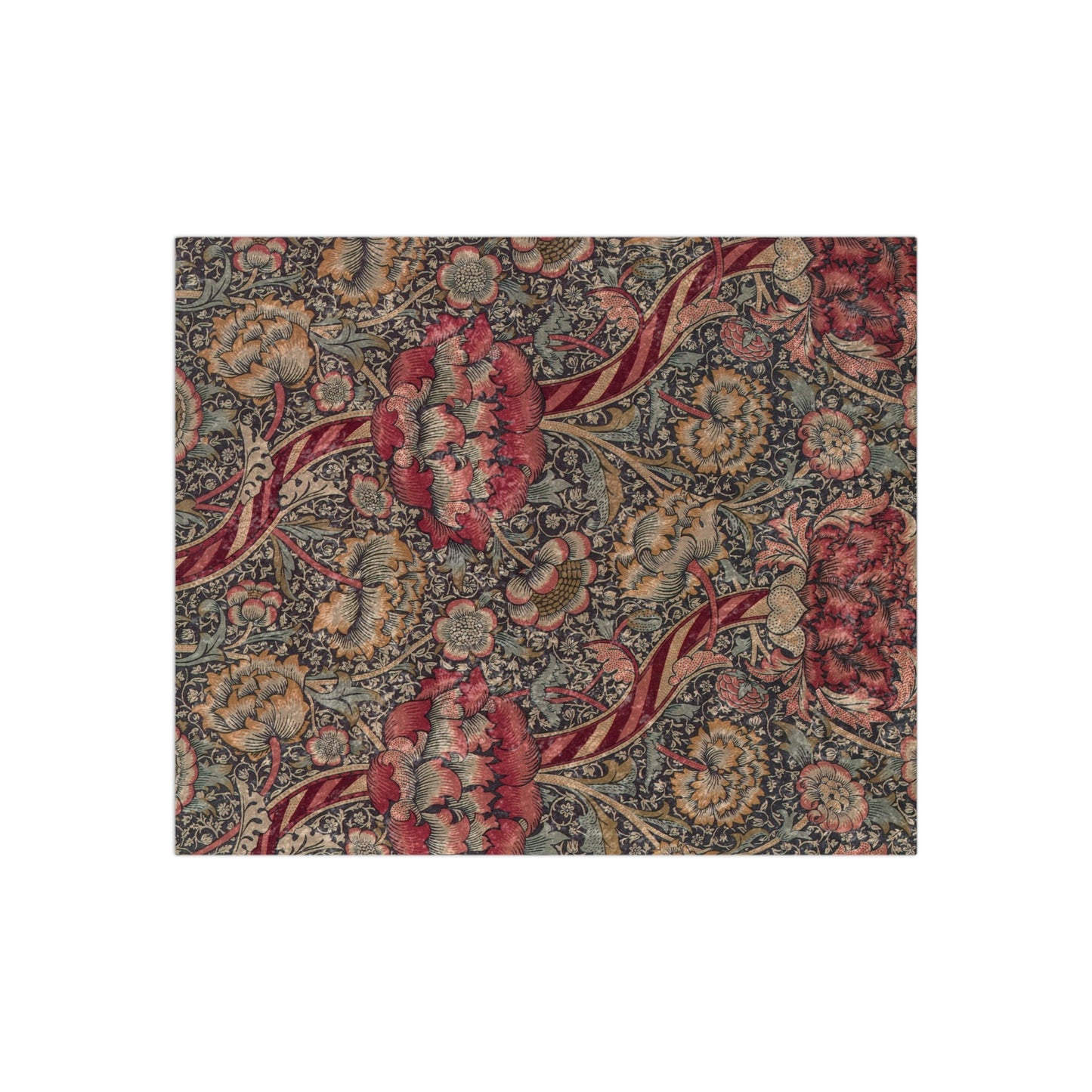 A crushed velvet blanket with a William Morris floral pattern in red and green colours, laid flat with hemmed edges visible.