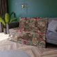 A crushed velvet blanket with a William Morris floral pattern in red and green colours, laid flat with hemmed edges visible.