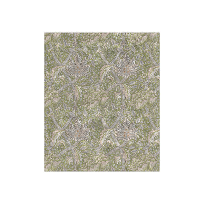 A plush, velvet blanket with a floral pattern in shades of green and beige, laid out with the soft side up.