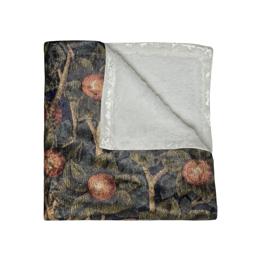 A lush crushed velvet blanket with a floral pattern inspired by William Morris, displayed in an folded arrangement to show both the patterned side and the silky finish.