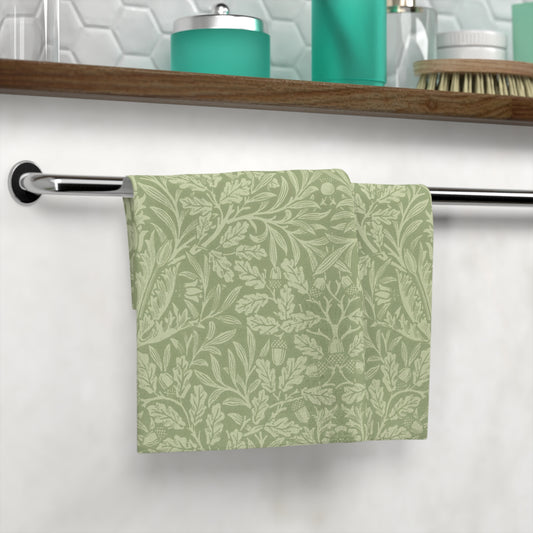 Green patterned towel hanging on a rack with a bathroom shelf in the background.