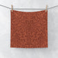 Red floral patterned fabric hanging on a line against a white background