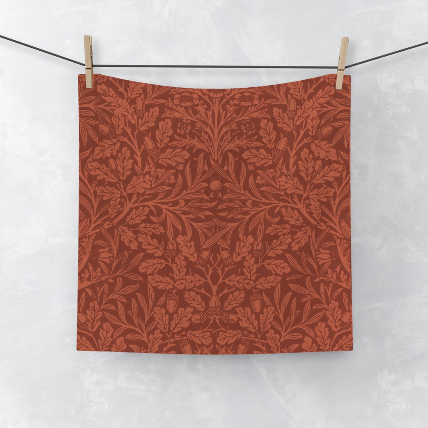 Red floral patterned fabric hanging on a line against a white background