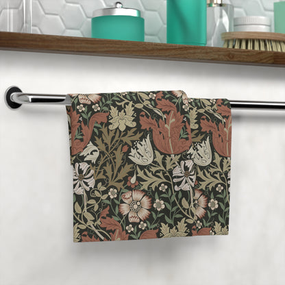Floral patterned towel hanging on a rack in a bathroom setting.