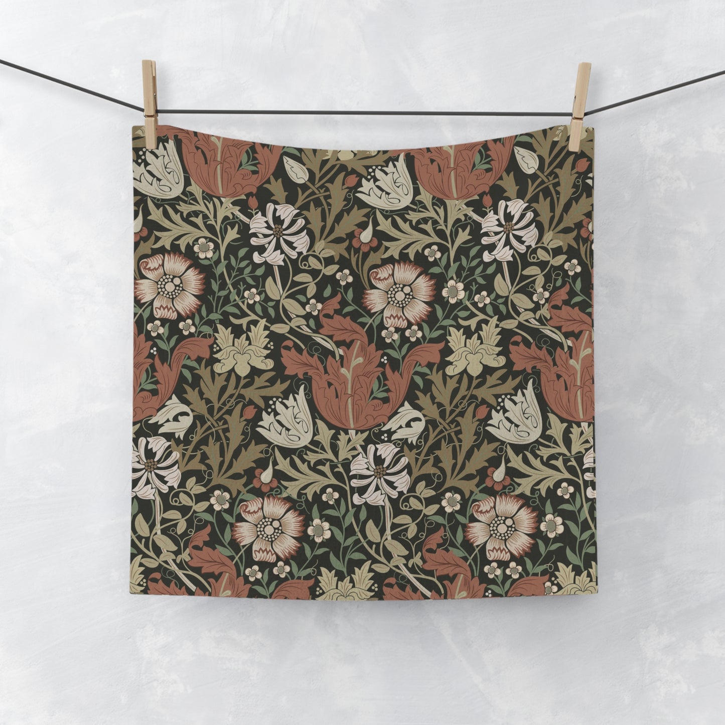 Floral patterned fabric hanging on a line against a white background