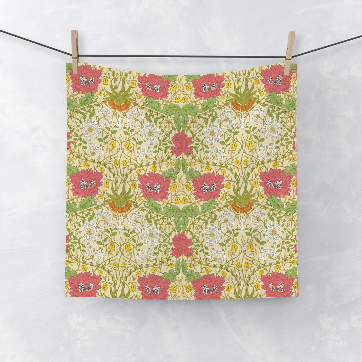 Floral patterned washcloth hanging on a line against a white background
