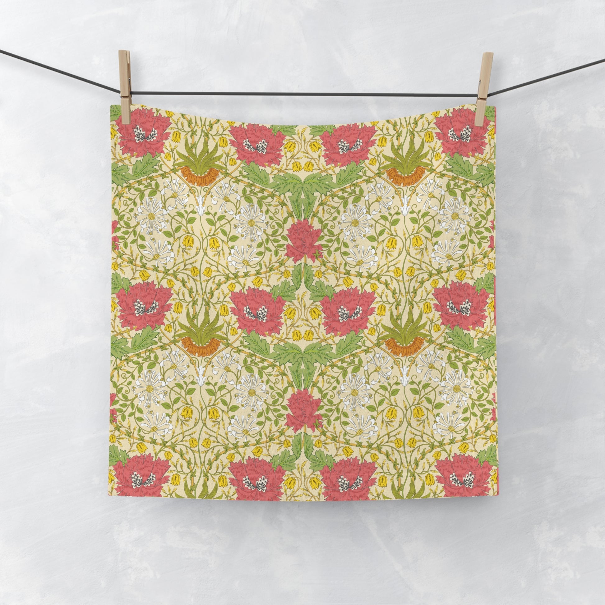 Floral patterned washcloth hanging on a line against a white background