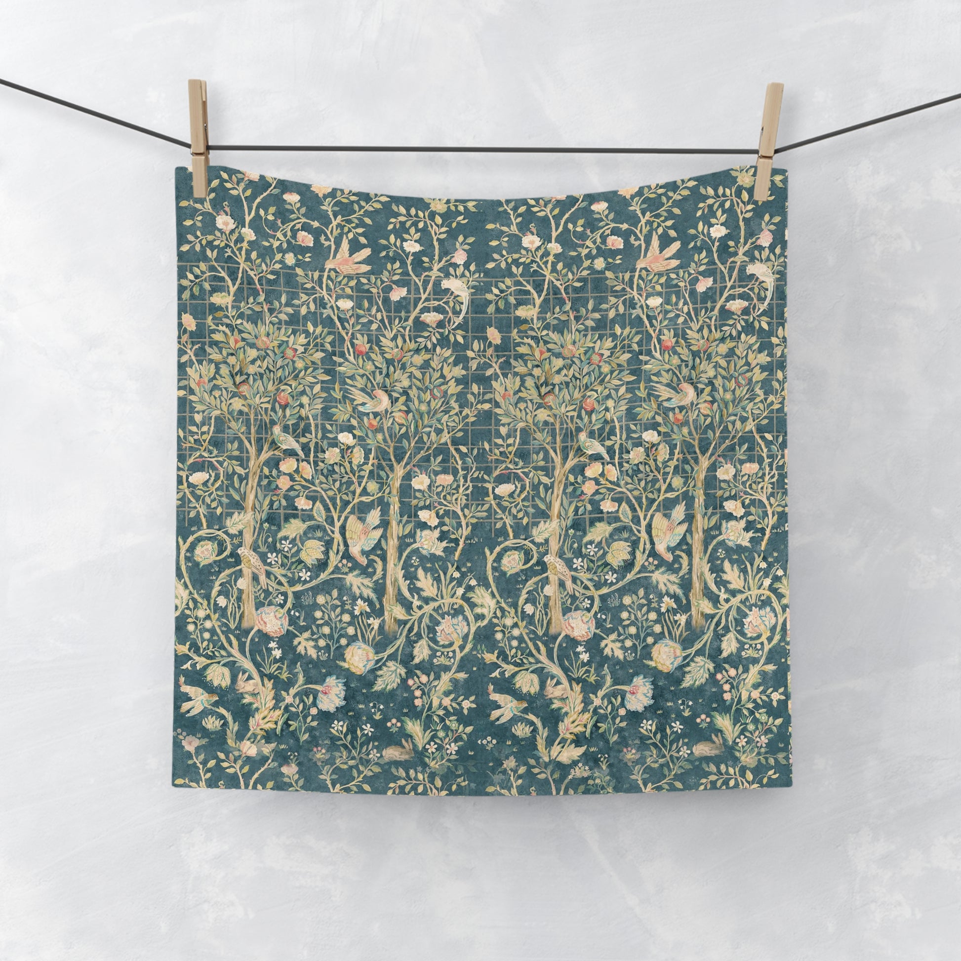 Floral patterned washcloth hanging on a line against a white background