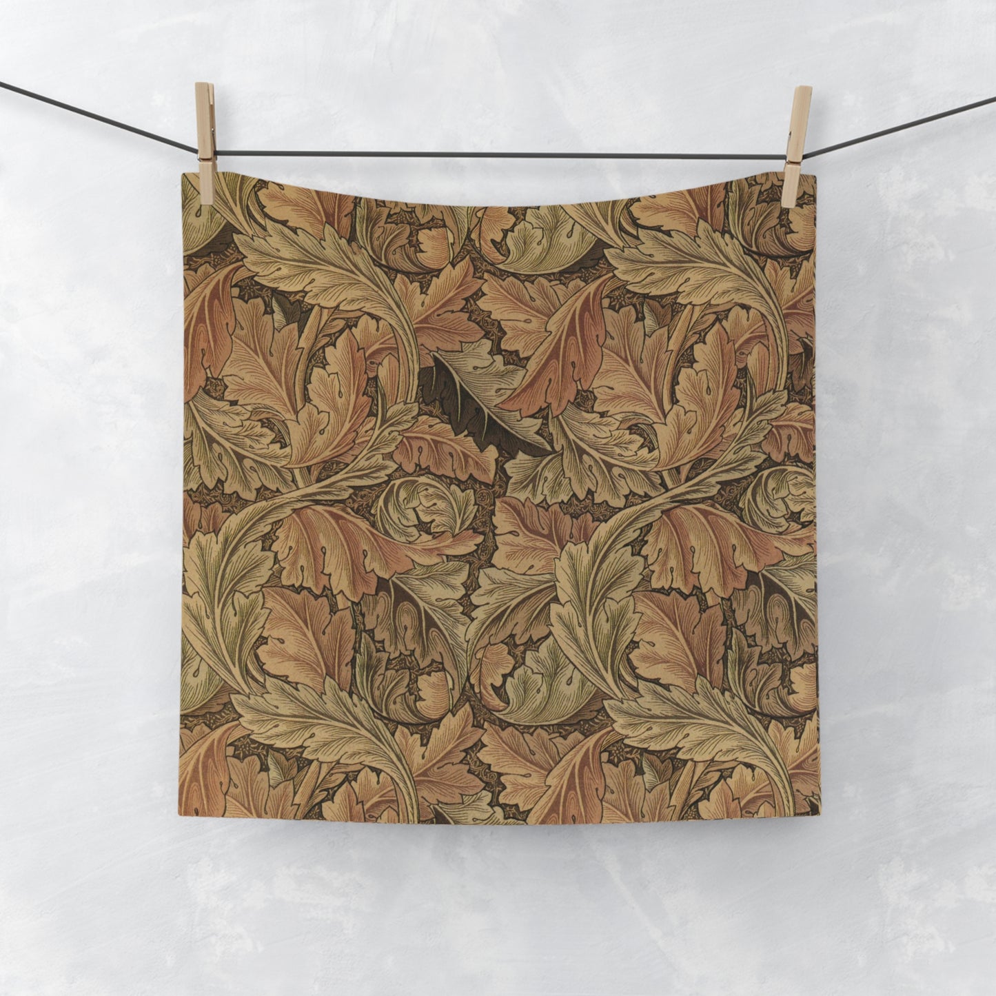 A brown and white washcloth with floral patterns inspired by William Morris, featuring leaves and acanthus designs.