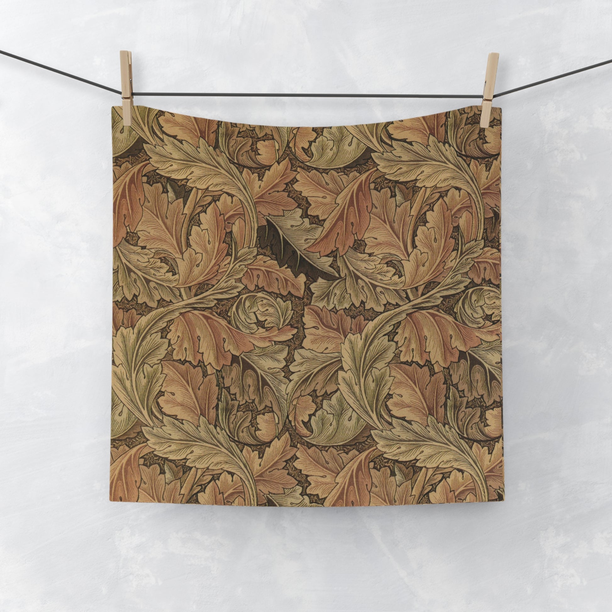A brown and white washcloth with floral patterns inspired by William Morris, featuring leaves and acanthus designs.