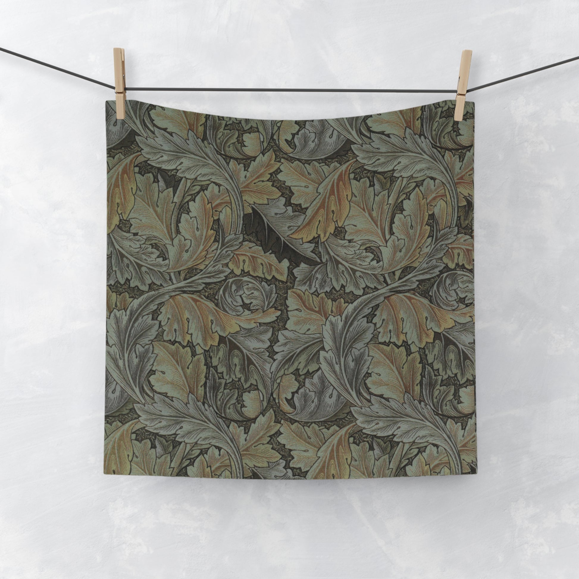 A gray washcloth with floral patterns inspired by William Morris, featuring a mix of leaf and acanthus designs.