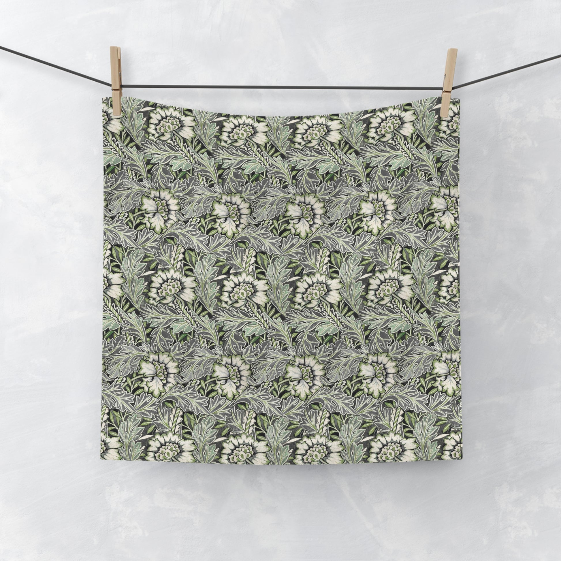 A gray washcloth with a floral pattern inspired by William Morris, featuring a design with leaves and anemone flowers.