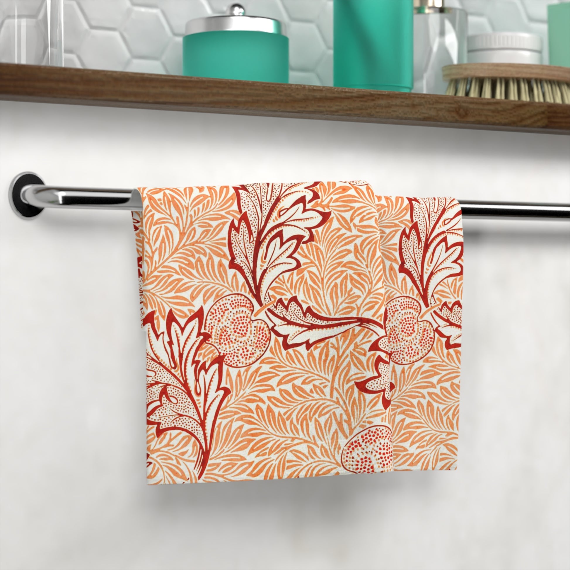 Washcloth with red floral pattern hanging on a rack in a bathroom.