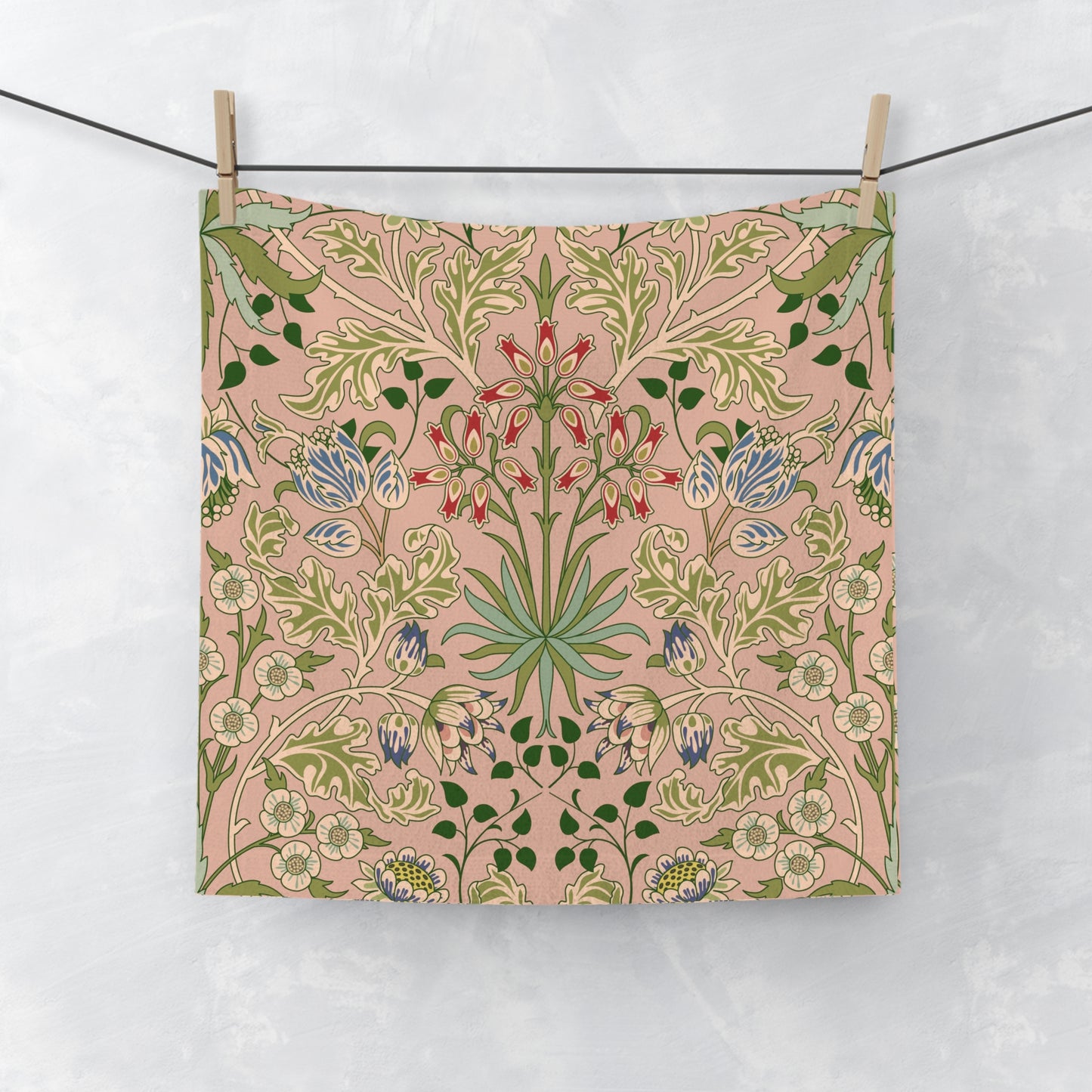 Floral patterned washcloth hanging on a line against a white background