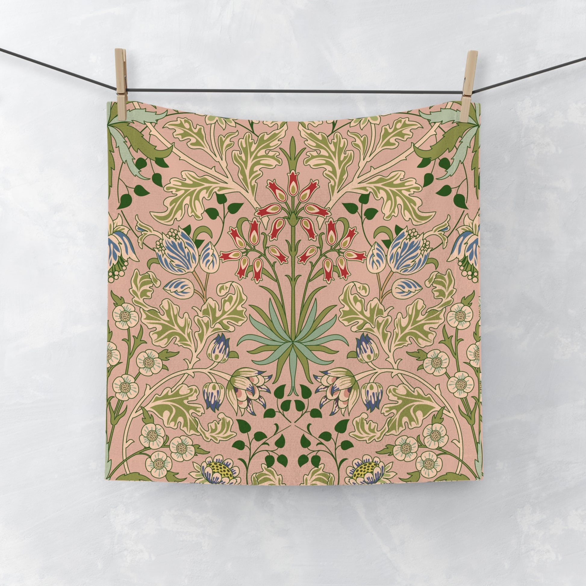 Floral patterned washcloth hanging on a line against a white background