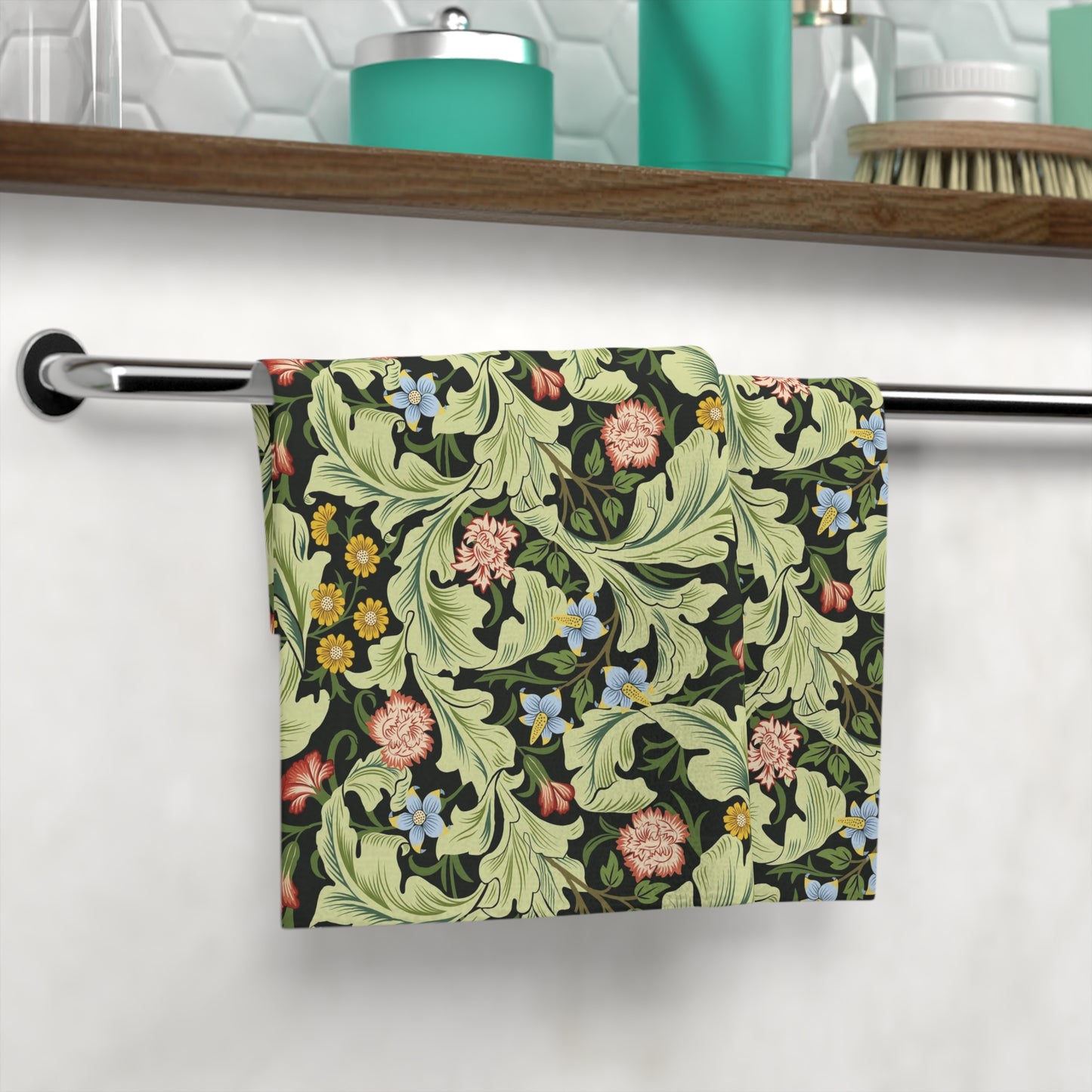 Floral patterned washcloth hanging on a rack with a bathroom setting in the background.