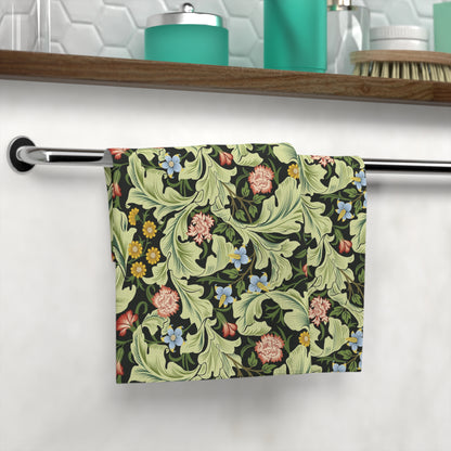 Floral patterned washcloth hanging on a rack with a bathroom setting in the background.