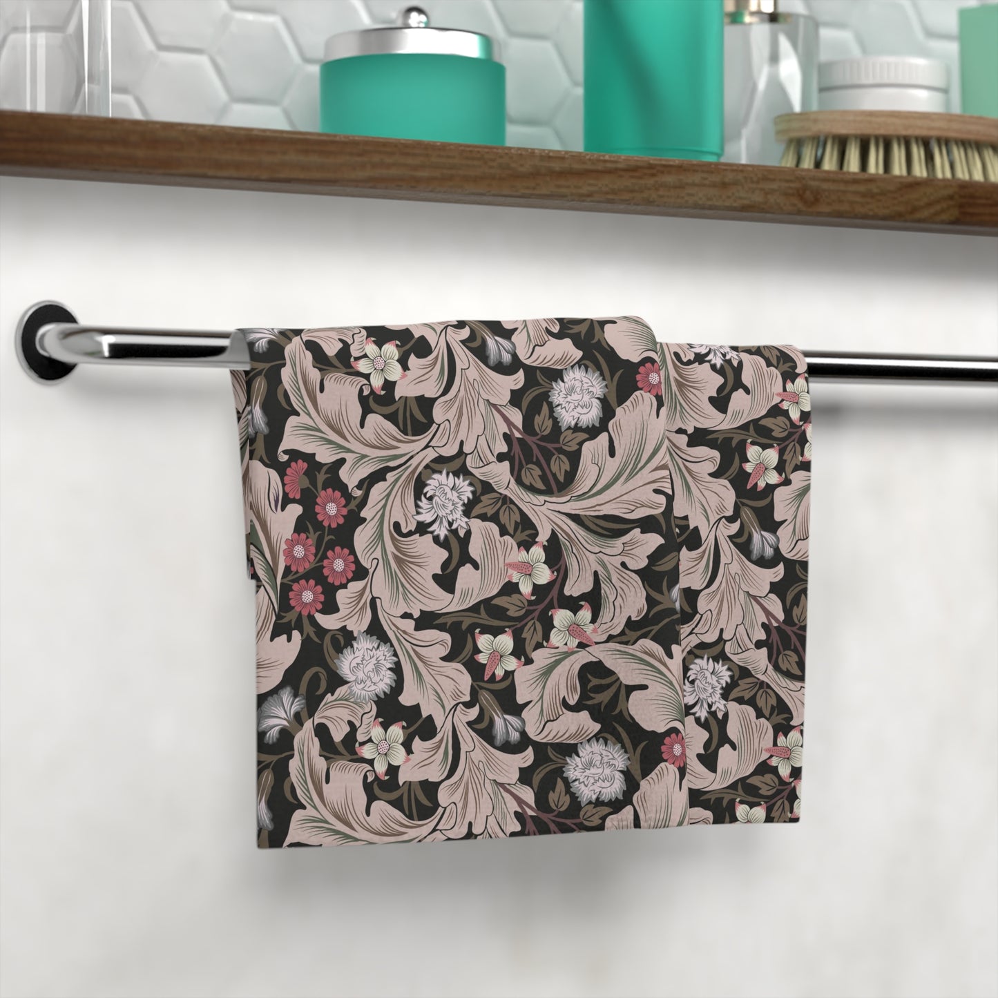 Floral patterned towel hanging on a rack with a bathroom setting in the background.