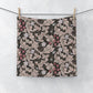 Floral patterned washcloth hanging on a line against a white background