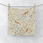 Fabric with a floral and bird pattern hanging on a line against a white background