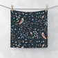 Fabric with nature-themed pattern featuring birds and plants hanging on a line.