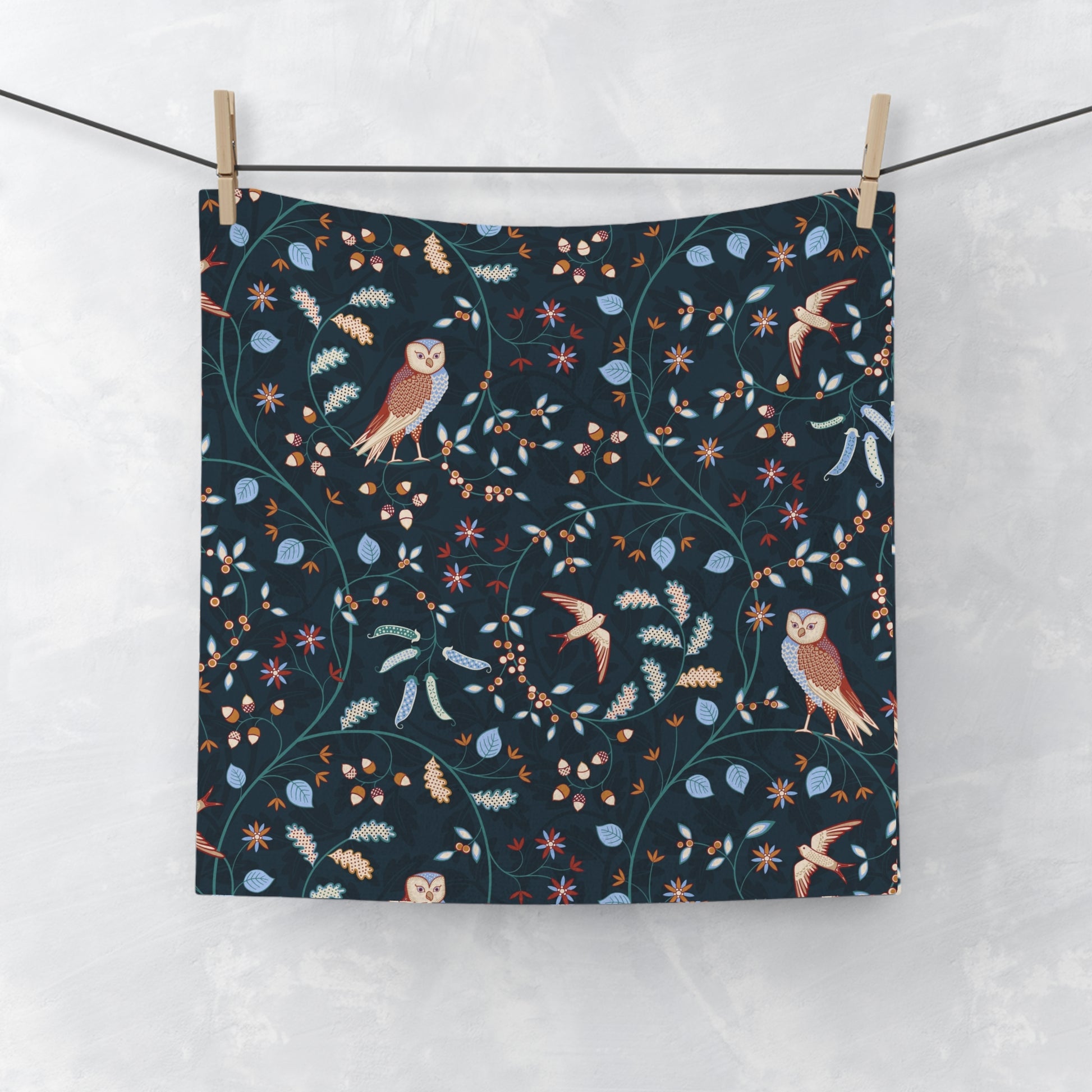 Fabric with nature-themed pattern featuring birds and plants hanging on a line.