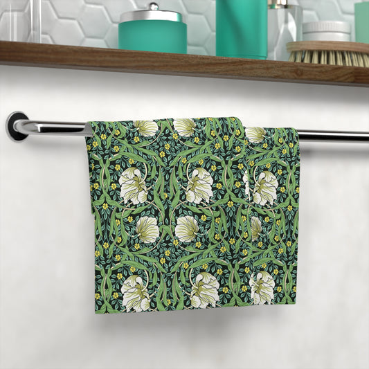 Floral patterned towel hanging on a rack with a bathroom setting in the background.
