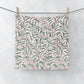 Floral patterned washcloth hanging on a line against a light background