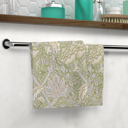 Floral patterned washcloth hanging on a towel rack in a bathroom setting.