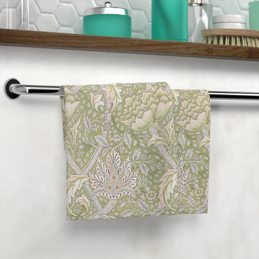 Floral patterned washcloth hanging on a towel rack in a bathroom setting.
